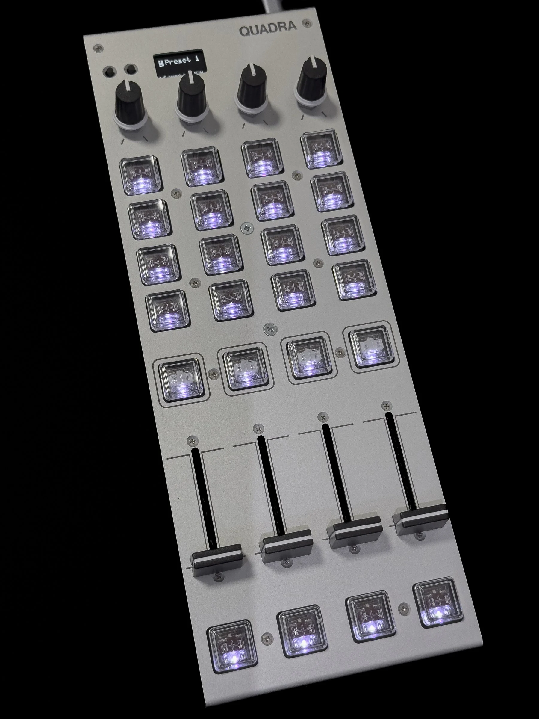 QUADRA の試作機を斜めから写した写真。銀色のアルミの天板に並んだ 24 キーが光っています